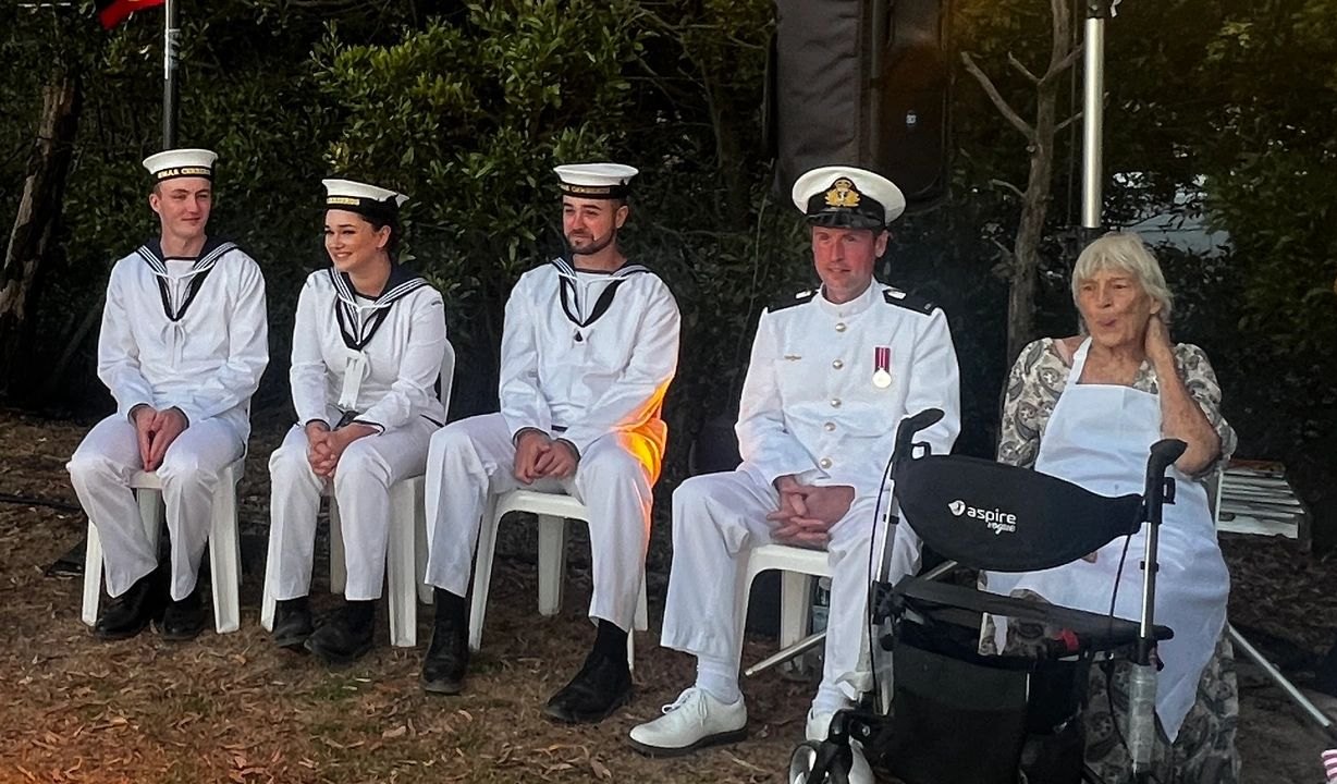 Royal Australian Navy sailors and an officer in white uniforms at an Australia House ceremony